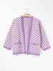 Checkerboard Alpaca Cardigan in a relaxed boxy fit, crafted from a soft alpaca blend with a black and natural checkerboard pattern, open front and front patch pockets.